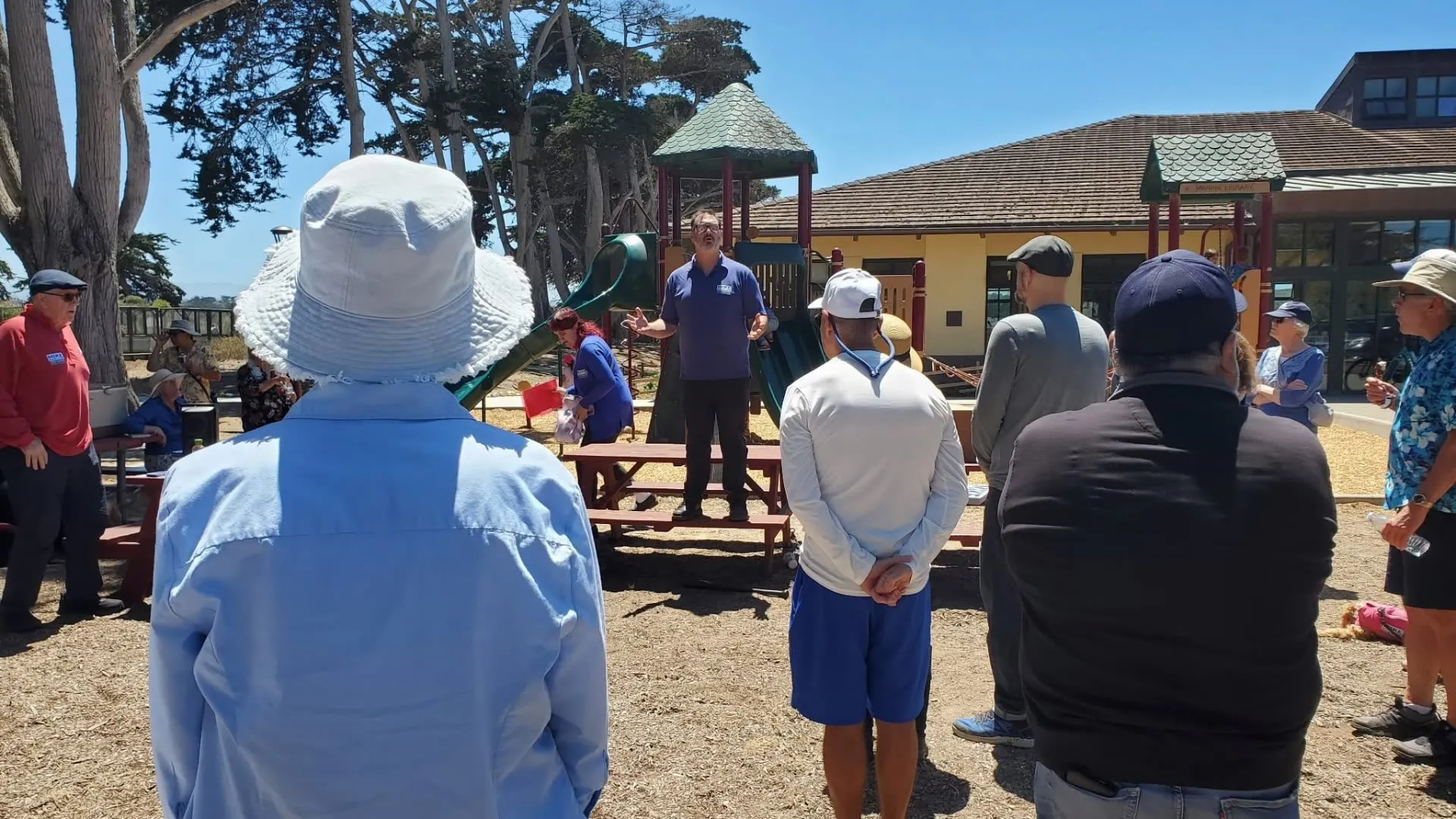 Mike Moeller speaking to residents gathered beside the playground at the Marina Library