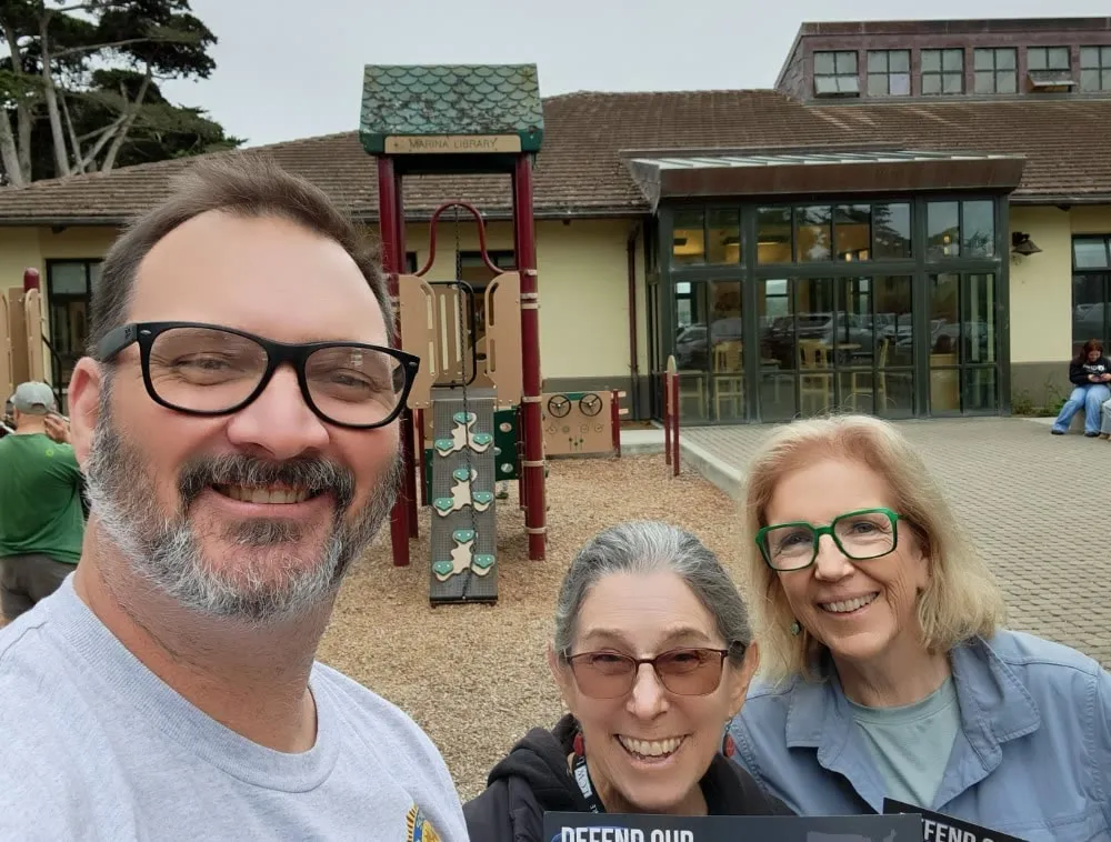 Mike Moeller with two volunteers outside the Marina Library